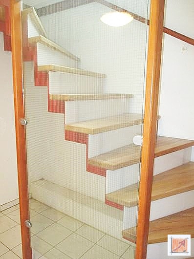 Moderne Metalltreppe mit Tritten aus Rüster-Holz und einem transparenten Geländer aus ESG-Sicherheitsglas im Holzhaus.